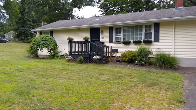 single story home with a deck, a chimney, and a front lawn