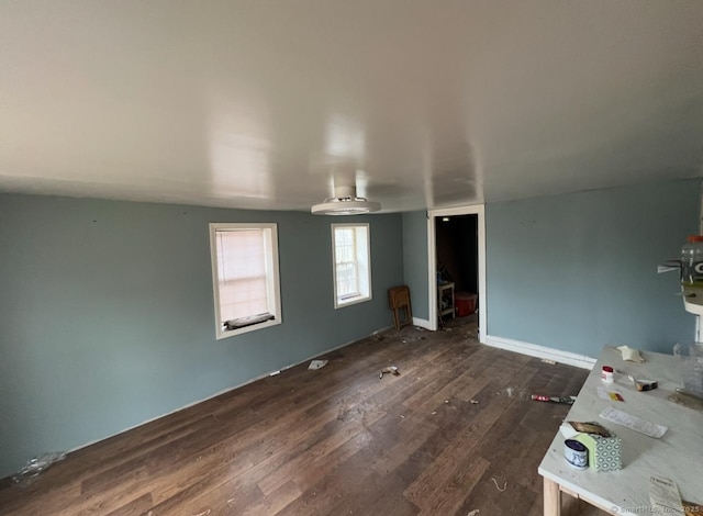 unfurnished room featuring dark wood-style floors and baseboards