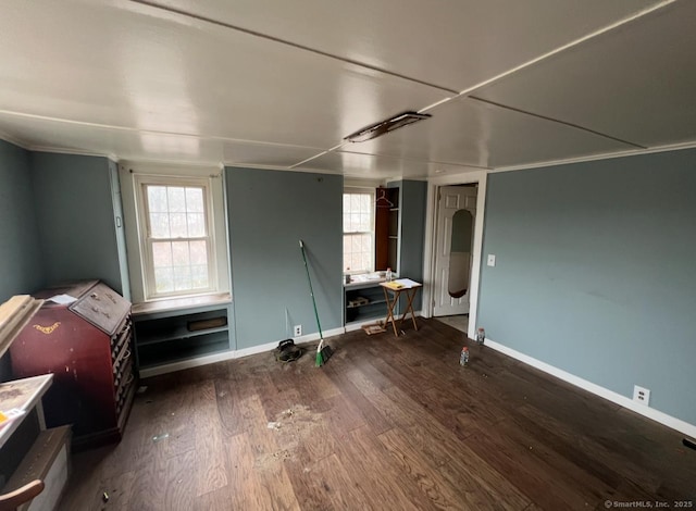 interior space with a wealth of natural light, baseboards, wood finished floors, and ornamental molding