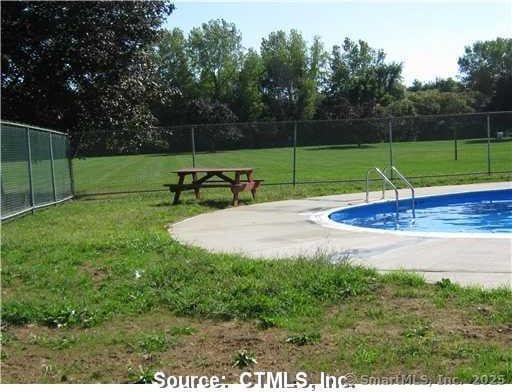 view of swimming pool with a lawn, a fenced in pool, and fence