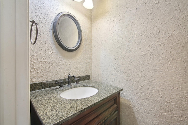 bathroom featuring vanity and a textured wall