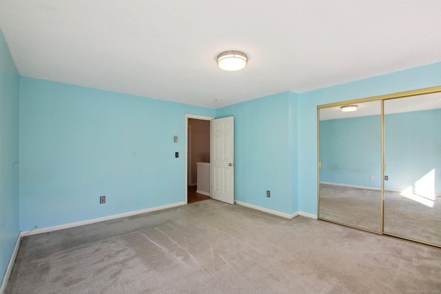 unfurnished bedroom featuring carpet flooring, baseboards, and a closet