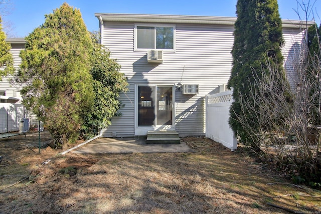 rear view of property featuring entry steps and fence