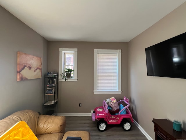 recreation room with baseboards and wood finished floors