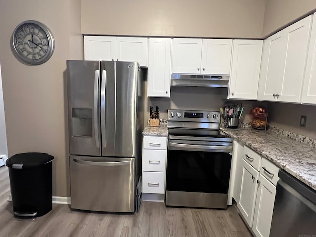 kitchen featuring white cabinets, under cabinet range hood, stainless steel appliances, and wood finished floors