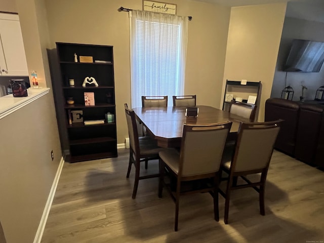 dining room featuring light wood-style flooring and baseboards