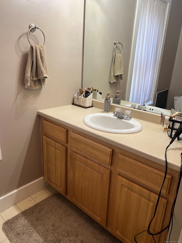 bathroom featuring tile patterned flooring, vanity, and baseboards