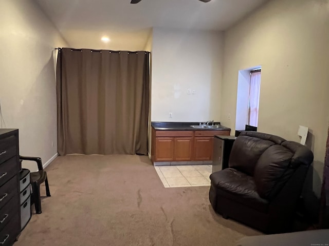 living area with light carpet, a ceiling fan, and light tile patterned flooring