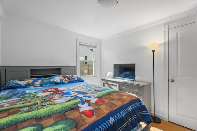 bedroom featuring light wood-style floors and crown molding