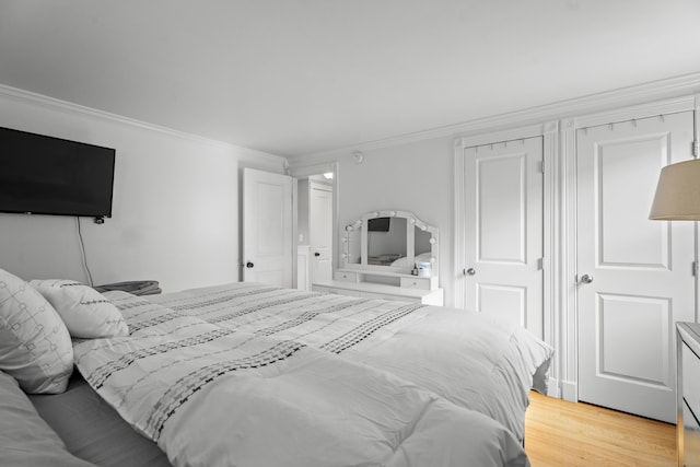 bedroom featuring light wood-style flooring and ornamental molding