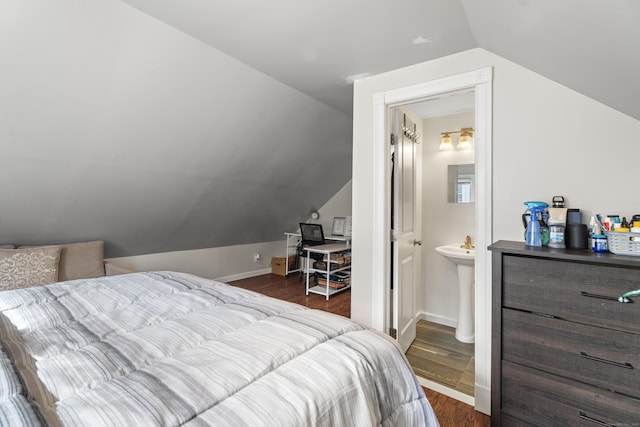 bedroom with baseboards, dark wood-type flooring, and lofted ceiling