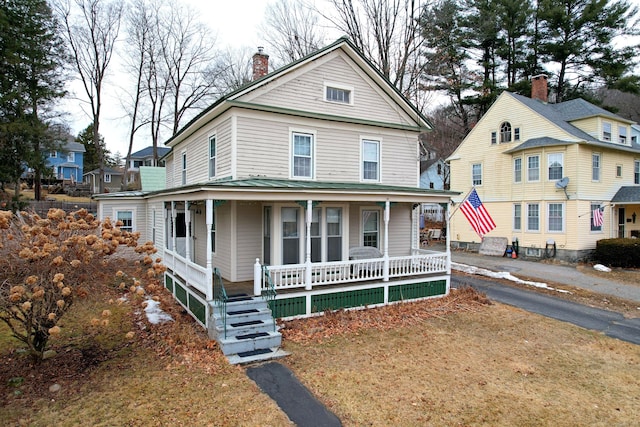 view of front of home featuring a chimney and a porch