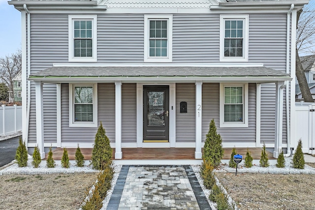 view of front of home with a porch and fence