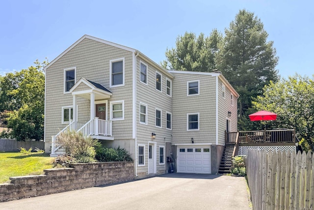 view of front of house with stairway, an attached garage, fence, and driveway