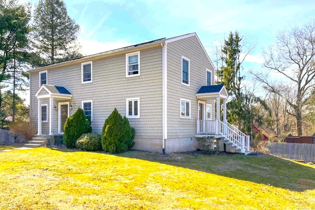 view of front of house featuring a front lawn and fence