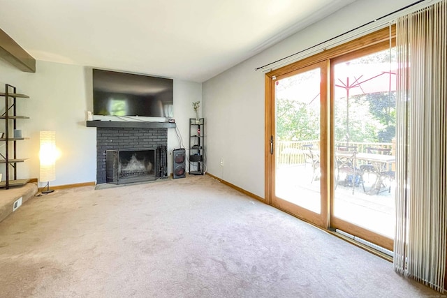 unfurnished living room with a brick fireplace, baseboards, and carpet floors