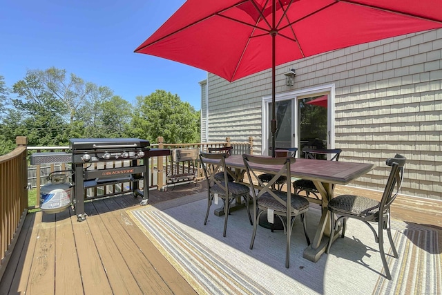 wooden terrace featuring outdoor dining area and grilling area