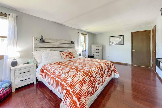 bedroom with wood finished floors and baseboards