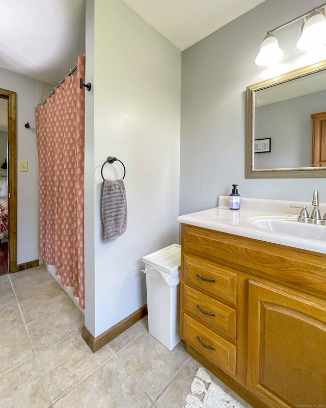 full bathroom featuring tile patterned flooring, vanity, a shower with shower curtain, and baseboards