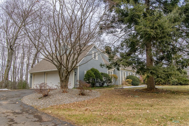 view of front of house with driveway and roof with shingles