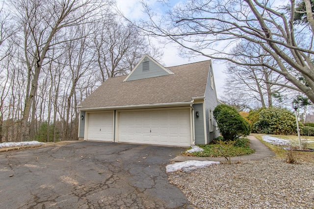 view of property exterior featuring a garage and a shingled roof