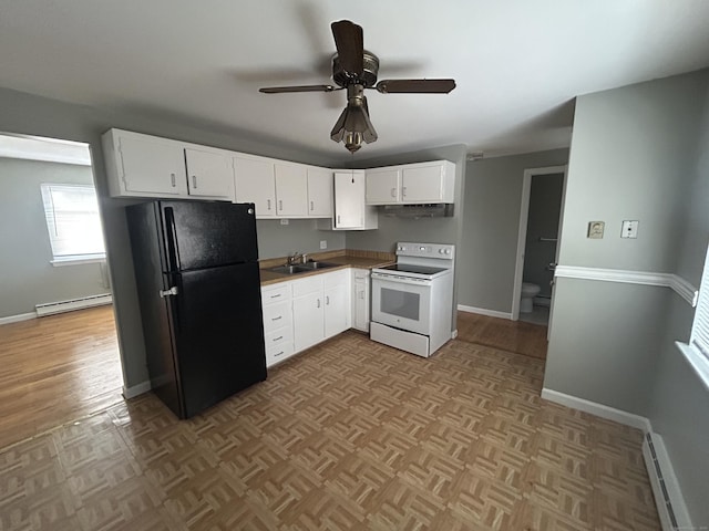 kitchen featuring a sink, white cabinetry, baseboard heating, freestanding refrigerator, and white range with electric stovetop