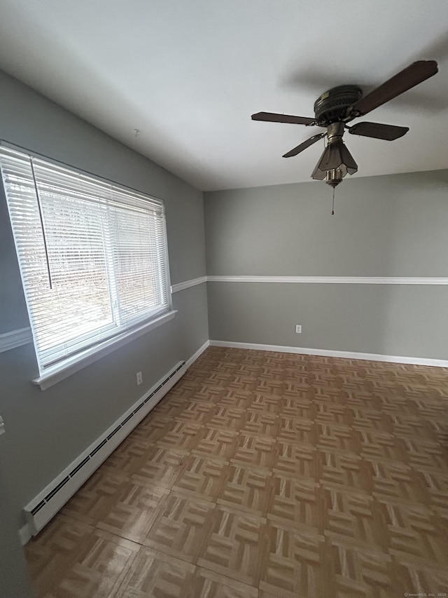 spare room featuring a baseboard heating unit, baseboards, and a ceiling fan