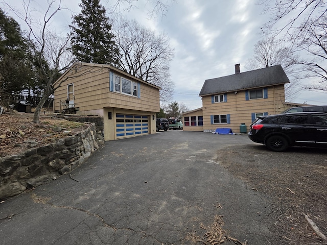 view of home's exterior with driveway and a chimney