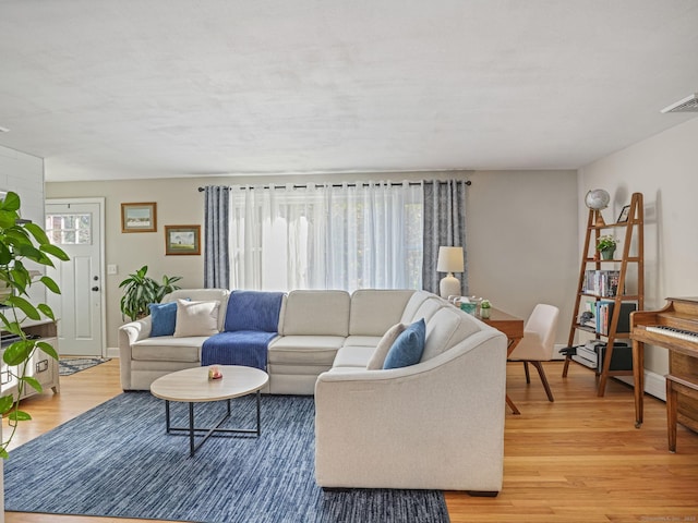 living area with light wood-type flooring and visible vents