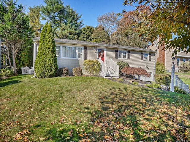 ranch-style house featuring fence and a front yard