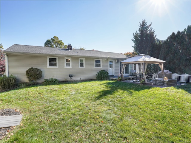 rear view of property with a lawn, a patio, a chimney, fence, and a gazebo