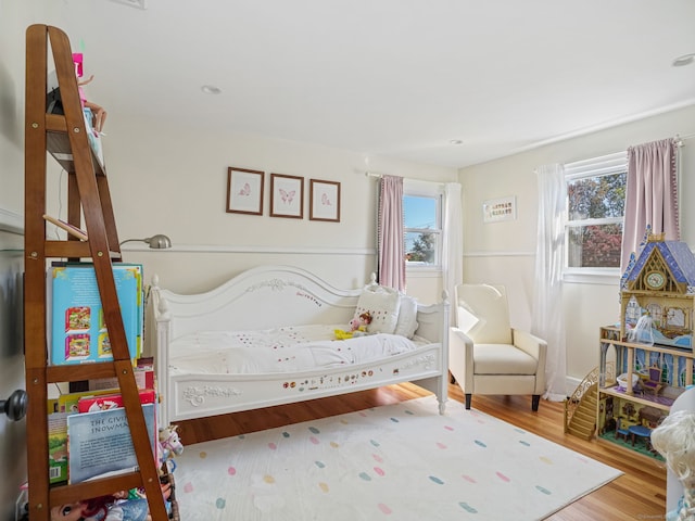 bedroom featuring multiple windows and wood finished floors