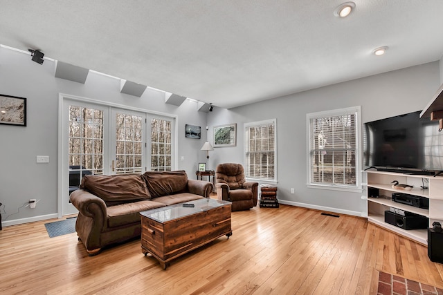 living area with visible vents, baseboards, and light wood finished floors