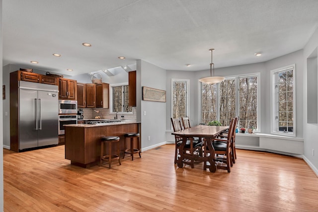 dining space featuring recessed lighting, baseboards, and light wood-style floors