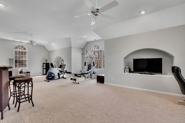 workout area featuring baseboards, carpet floors, ceiling fan, and vaulted ceiling