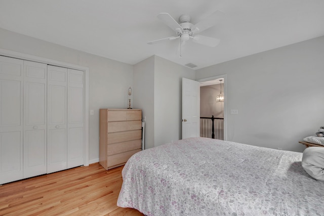 bedroom with ceiling fan, visible vents, a closet, and light wood-style flooring