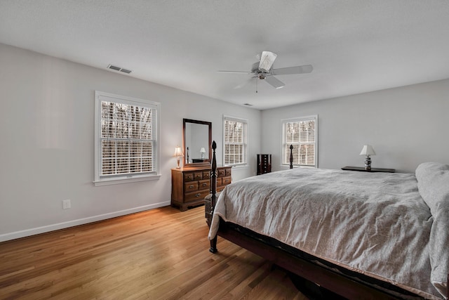 bedroom with visible vents, baseboards, light wood-style flooring, and a ceiling fan