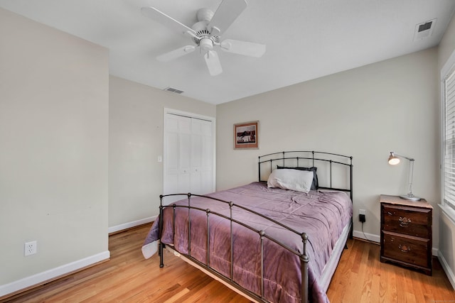 bedroom with visible vents, baseboards, light wood-style floors, and a closet