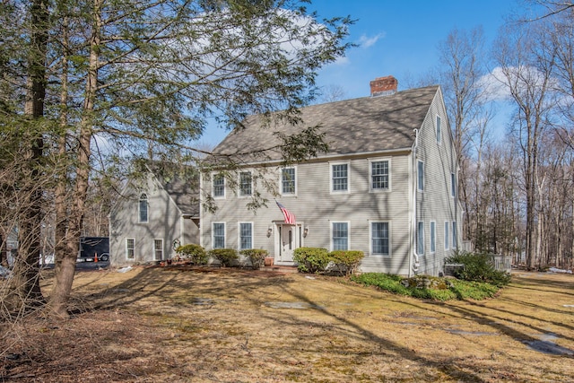 colonial house with a front lawn and a chimney