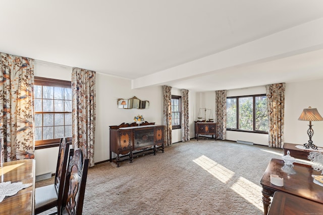 living area with beam ceiling, carpet, and baseboards