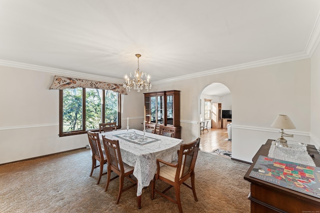 dining space featuring baseboards, arched walkways, carpet, and ornamental molding