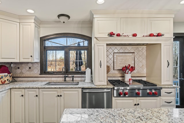 kitchen with a sink, stainless steel appliances, light stone countertops, and tasteful backsplash