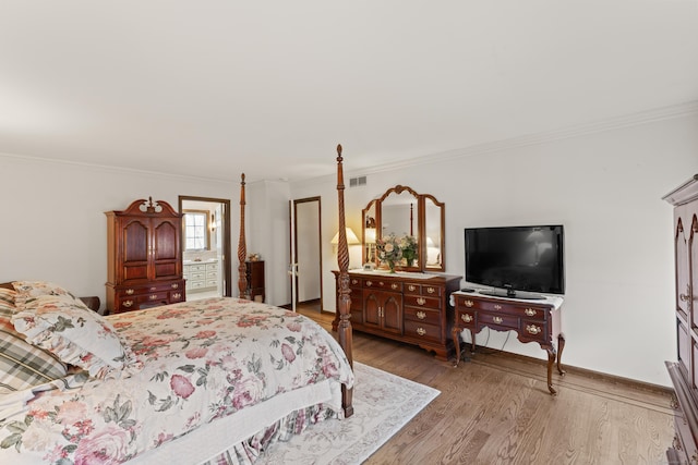 bedroom featuring visible vents, light wood-style flooring, ornamental molding, connected bathroom, and baseboards