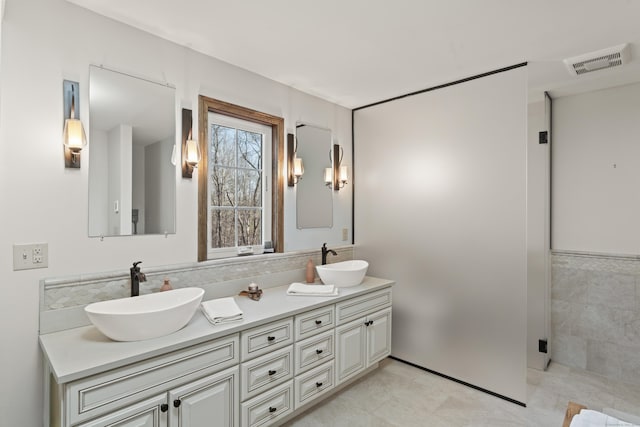 bathroom featuring double vanity, visible vents, tile patterned floors, and a sink