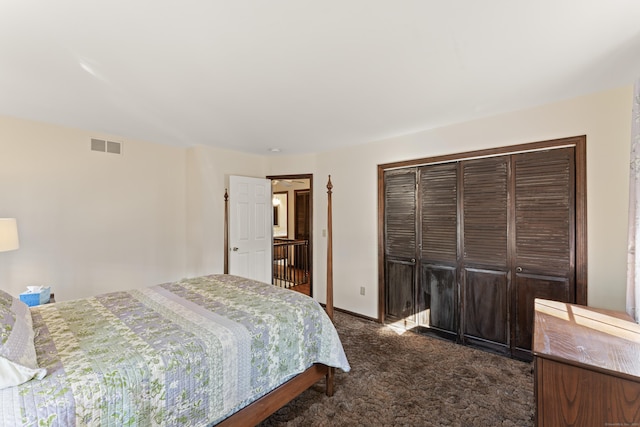 bedroom featuring a closet, visible vents, baseboards, and dark colored carpet