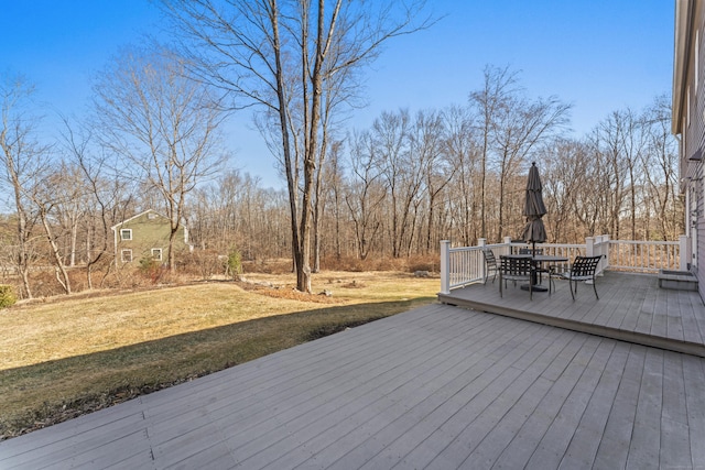 deck with outdoor dining space and a yard