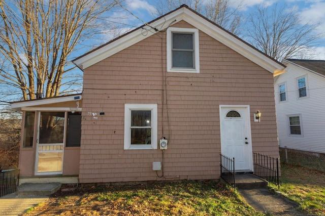 view of front of property featuring fence and a sunroom