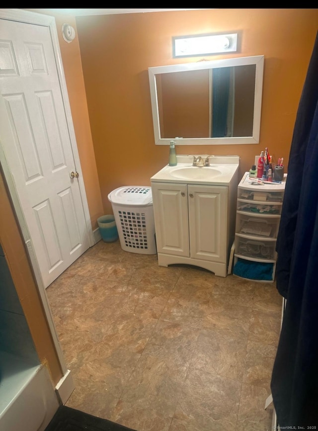 full bath featuring a tub to relax in and vanity