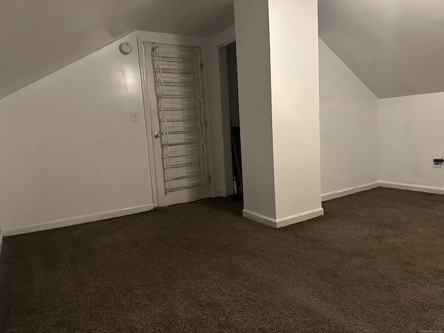 bonus room featuring lofted ceiling, baseboards, and dark colored carpet