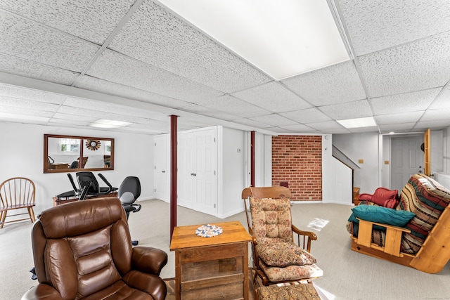 carpeted living room featuring baseboards and a paneled ceiling